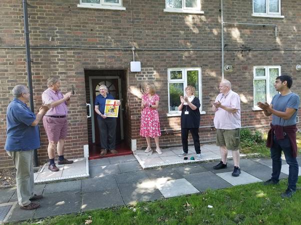 A group of people standing in front of a building Description automatically generated