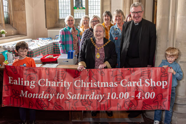 Pictured at the opening are (front, l-r): Councillor Yvonne Johnson, Mayor of the London Borough of Ealing, Sue Green, Founder, Ealing Charity Christmas Card Shop and Father Richard Collins, Vicar of Parish Church of Christ the Saviour. The banner is being held by James and Ben Ellis, grandsons of Mrs Green.