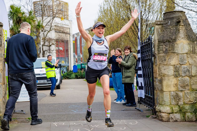 First female finisher Laura Egerton crosses the finish line of the Queen of the Suburbs Ultra in Dickens Yard